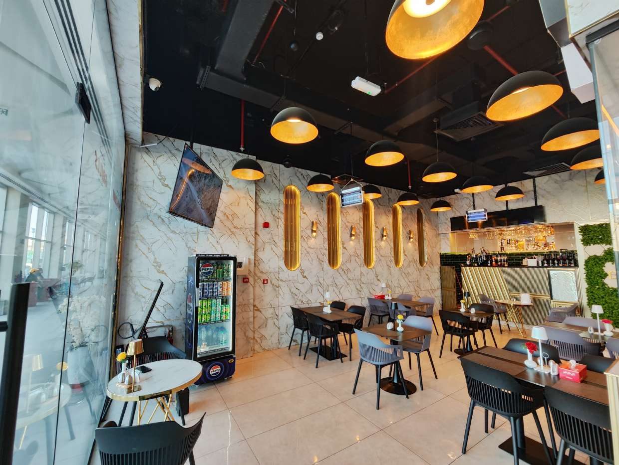 Dream Sip Restaurant interior with marble walls and gold light fixtures